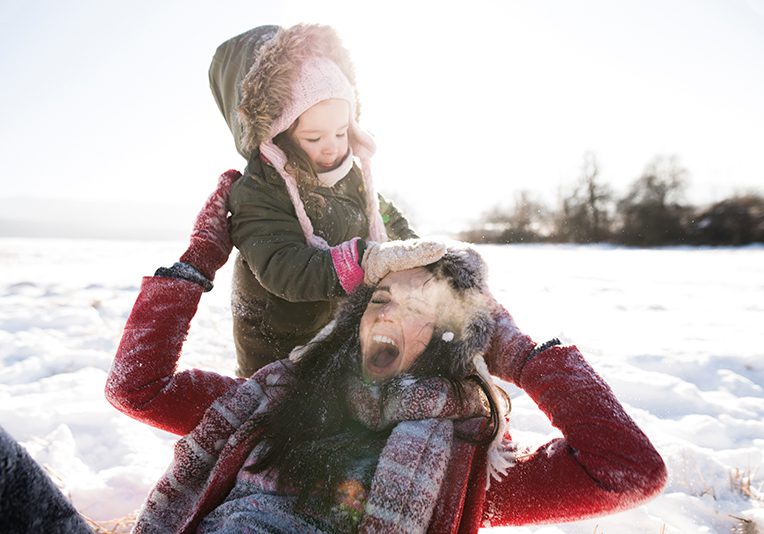 Mother and daughter rejoicing in the middle of the snow